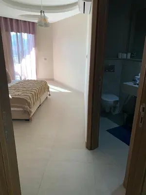 a bedroom with a bed and a bathroom with a toilet at Appartement neuf climatisé, centre Marrakech. in Marrakech
