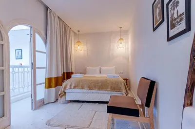 a bedroom with a bed and a chair in it at Riad K-white in Marrakech