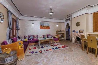a living room with a purple couch and a fireplace at Alqantara in Marrakech