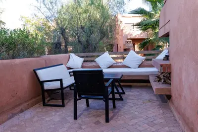 two chairs and a table and a couch on a patio at Alqantara in Marrakech