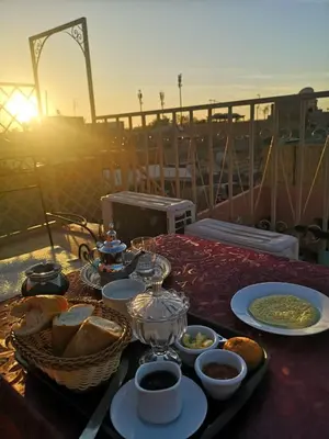a table with plates of food on top of a balcony at El Boussouni Hostel in Marrakech