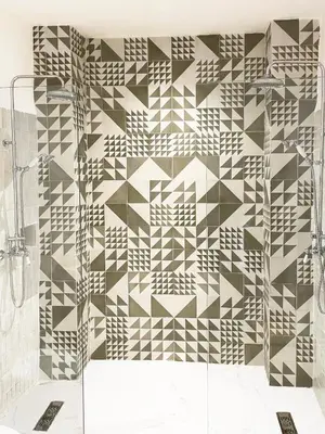a bathroom with a geometric tile wall at Riad Al Uzza in Marrakech