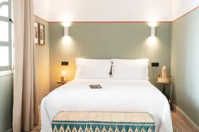 a bedroom with a large white bed with white pillows at Riad Al Uzza in Marrakech