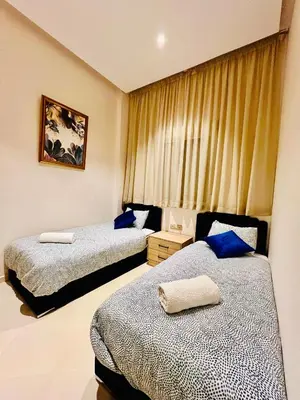 a hotel room with two beds and a window at Stay In Marrakech Blue Appartment in Marrakech