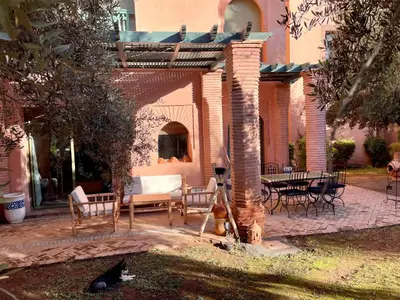 a brick patio with chairs and a table and chairs at Les Fleurs du Bien - Marrakech in Marrakech