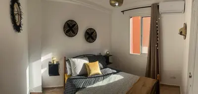 a bedroom with a bed and two clocks on the wall at Escale Marrakech in Marrakech