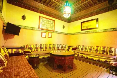 a living room with a couch and a table at Riad Kamal prés Medina Marrakech & 3 Piscines & Jacuzzi & Petit-Déjeuner in Marrakech