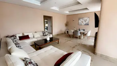 a living room with a white couch and a table at Private Villa BSF - Pool & Spa - Palm Golf in Marrakech