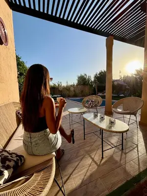 a woman sitting on a chair on a patio at Private Villa BSF - Pool & Spa - Palm Golf in Marrakech