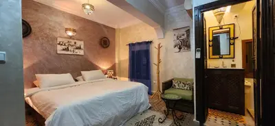 a bedroom with a bed and a chair in it at Riad Dar Si Driss in Marrakech