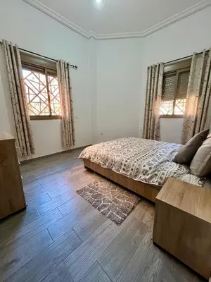a bedroom with a bed and two windows at MyZo Superbe Appartement familial bien situé à Marrakech in Marrakech