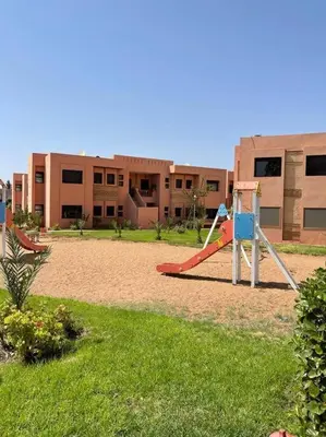 a playground in front of a building with a slide at Merveilleuse Marrakech! in Marrakech