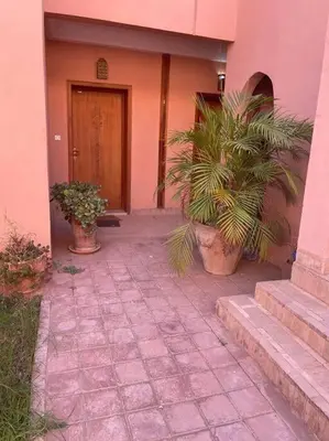 a house with two potted plants in front of a door at Merveilleuse Marrakech! in Marrakech