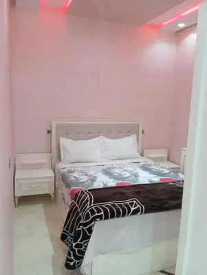 a bedroom with a bed and a pink wall at Redone in Marrakech