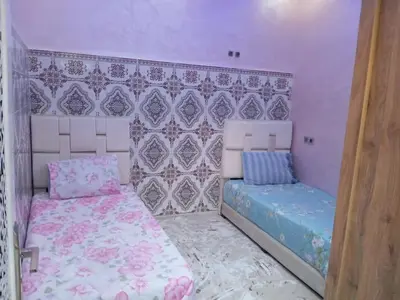 a bedroom with two beds in a room with purple walls at Redone in Marrakech