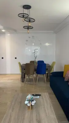 a living room with a table and a blue couch at Résidence Elsalam Marrakech in Marrakech