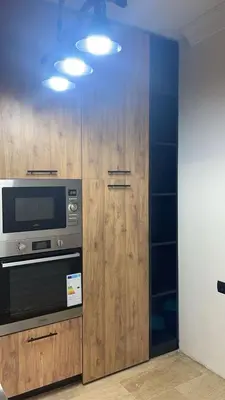 a kitchen with wooden cabinets and a microwave at Résidence Elsalam Marrakech in Marrakech