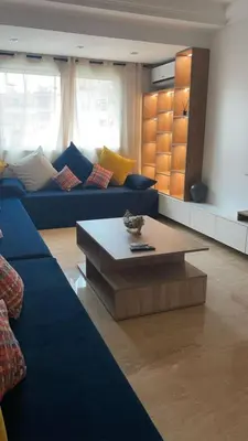 a living room with a blue couch and a coffee table at Résidence Elsalam Marrakech in Marrakech