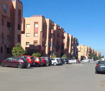 a row of cars parked in a parking lot next to buildings at Angel Appartement in Marrakech