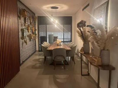 a dining room with a wooden table and chairs at Villa Bohème avec personnel de maison in Marrakech