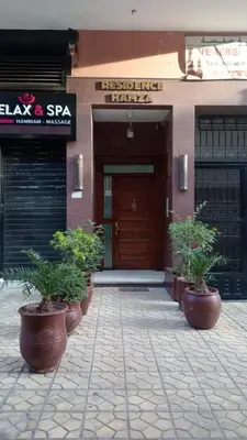a building with potted plants in front of a door at RESIDENCE HAMZA Cosy appartement only family à Gueliz in Marrakech