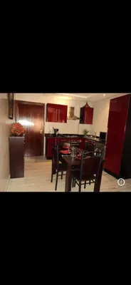 a kitchen with red cabinets and a table and chairs at RESIDENCE HAMZA Cosy appartement only family à Gueliz in Marrakech
