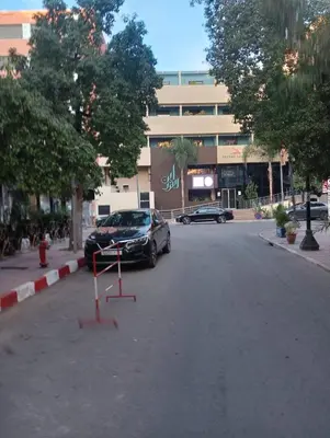 a car parked in a parking lot in front of a building at RESIDENCE HAMZA Cosy appartement only family à Gueliz in Marrakech