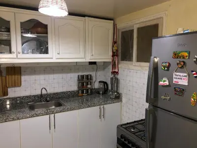 a kitchen with white cabinets and a stainless steel refrigerator at Riad Ramona lQariya seyaheya in Marrakech