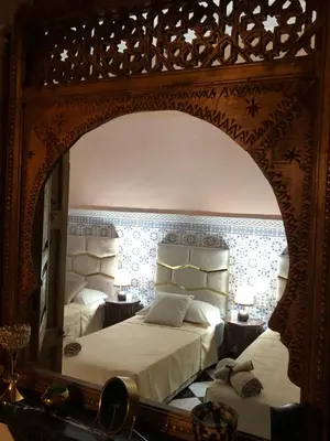 a bedroom with a bed and a large mirror at Riad Ramona lQariya seyaheya in Marrakech