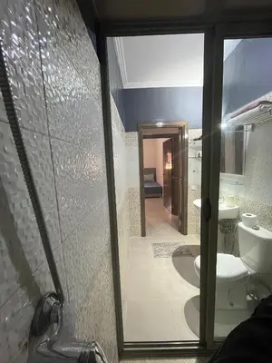 a bathroom with a toilet and a glass door at Appartement aéroport Marrakech in Marrakech