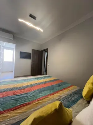 a bedroom with a large bed with a colorful blanket at Appartement aéroport Marrakech in Marrakech