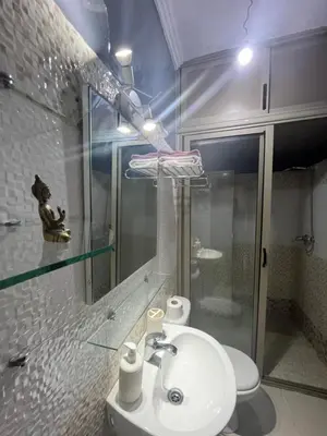 a bathroom with a sink and a glass shower at Appartement aéroport Marrakech in Marrakech