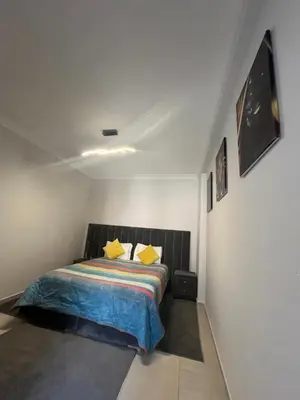 a bedroom with a bed with yellow pillows at Appartement aéroport Marrakech in Marrakech