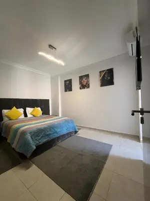 a bedroom with a bed and some pictures on the wall at Appartement aéroport Marrakech in Marrakech