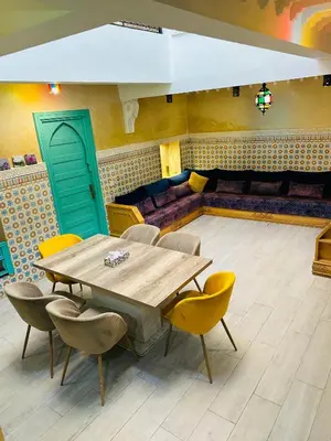 a dining room with a table and chairs and a couch at DAR AL NOUR in Marrakech
