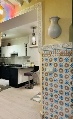 a kitchen with a counter and a table with a chair at DAR AL NOUR in Marrakech