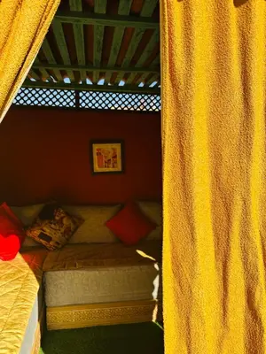 a bed in a room with a curtain next to it at DAR AL NOUR in Marrakech