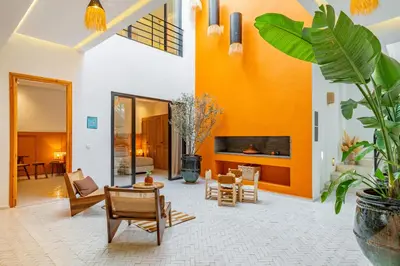 a living room with orange walls and furniture at RIAD LE M neuf et contemporain in Marrakech