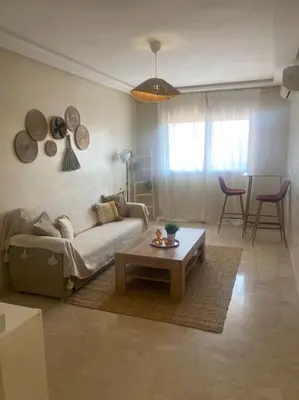 a living room with a couch and a coffee table at Bel appart wifi balcon et parking Marrakech centre in Marrakech