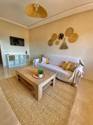 a living room with a couch and a coffee table at Bel appart wifi balcon et parking Marrakech centre in Marrakech