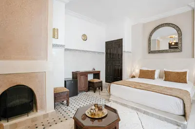a hotel room with a bed and a fireplace at RIAD ELNOUJOUM in Marrakech