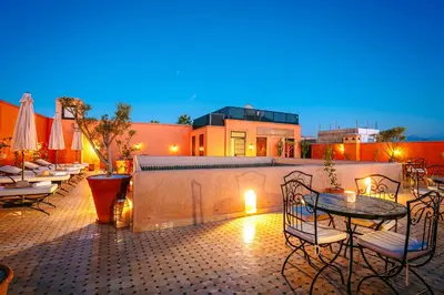 a patio with a table and chairs on a patio at RIAD ELNOUJOUM in Marrakech