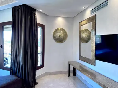 a room with a bench and a mirror and a window at Superbe appartement de luxe a l'hivernage marrakech in Marrakech