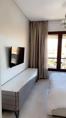 a bedroom with a bed and a tv on the wall at Superbe appartement de luxe a l'hivernage marrakech in Marrakech