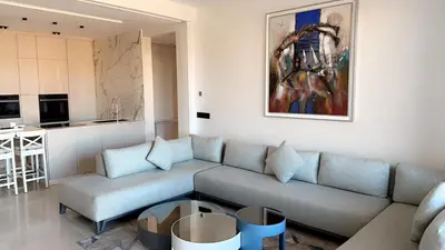 a living room with a couch and a kitchen at Superbe appartement de luxe a l'hivernage marrakech in Marrakech