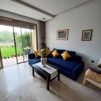 a living room with a blue couch and a table at Appartement de luxe Prestigia in Marrakech