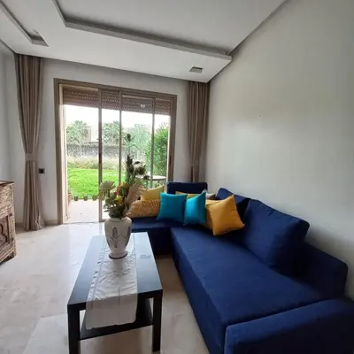 a living room with a blue couch and a table at Appartement de luxe Prestigia in Marrakech