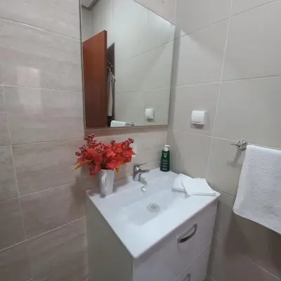 a white bathroom with a sink and a mirror at Appartement de luxe Prestigia in Marrakech