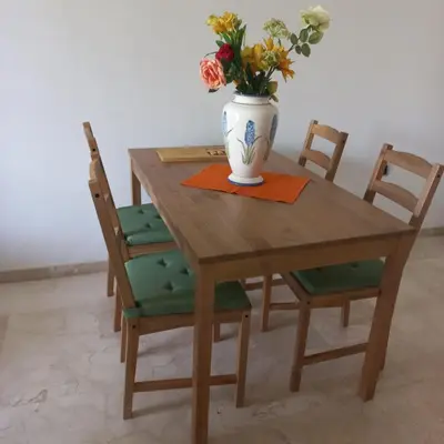 a wooden table with a vase with flowers on it at Appartement de luxe Prestigia in Marrakech