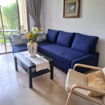 a blue couch in a living room with a table at Appartement de luxe Prestigia in Marrakech